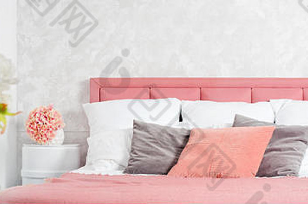 时尚的室内现代卧室白色粉红色的设计舒适的卧室花特大号的床上粉红色的灰色床上用品