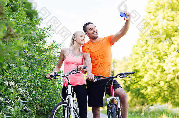夫妇自行车采取自拍智能手机