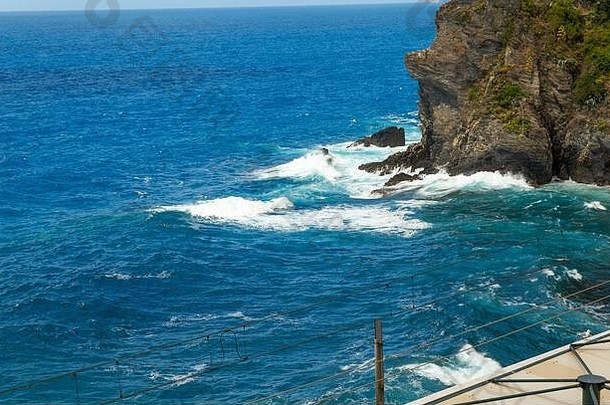 大蓝色的海波使白色泡沫崩溃岩石海滨悬崖