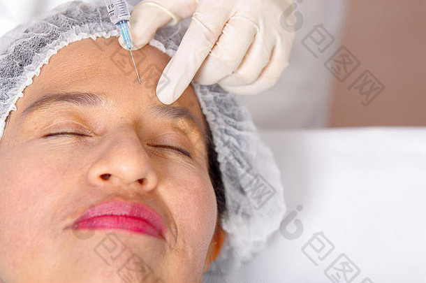 特写镜头女士脸接收肉毒杆菌注射注射器化妆品手术概念