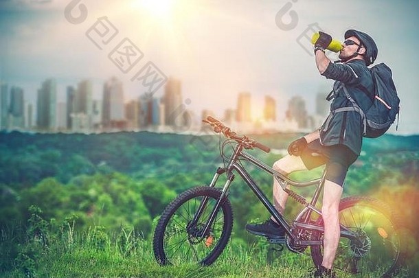 山骑自行车城市山骑摩托车的人让人耳目一新身体喝新鲜的冷水