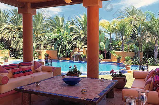 平铺的咖啡表格舒适的沙发阳台西班牙语别墅绿松石游泳池流苏棕榈树