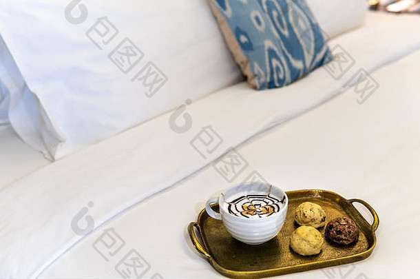 卡布奇诺咖啡花俏的巧克力设计前特里烤饼干黄金托盘酒店房间床上