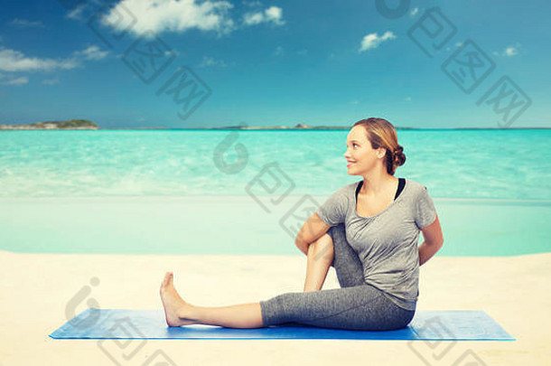 女人使瑜伽扭构成席海滩