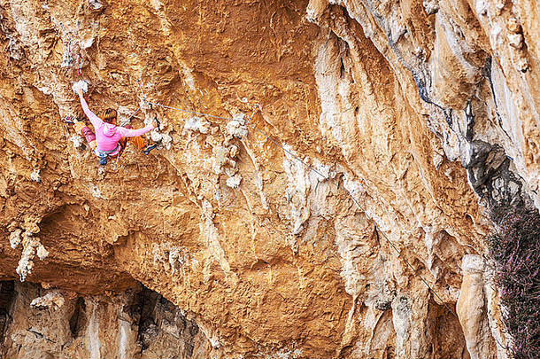 年轻的女岩石登山者悬崖脸