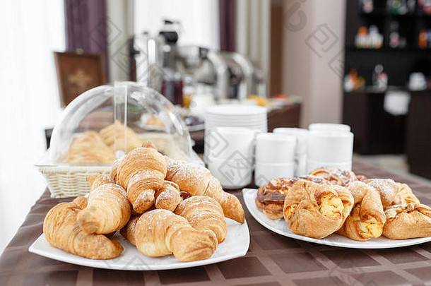 新鲜的羊角面包白色板法国传统的糕点早餐酒店瑞典式自助餐