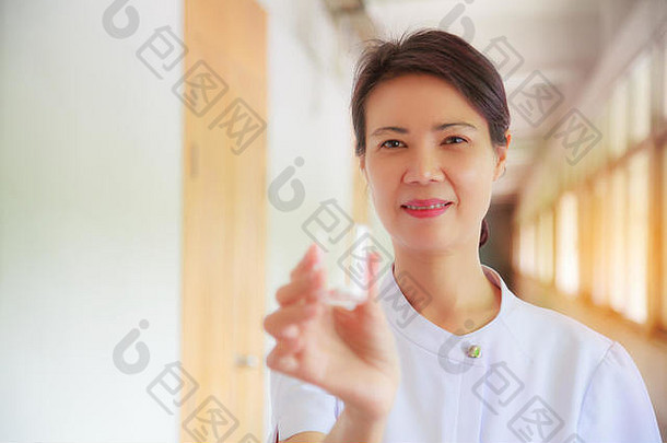 微笑女护士持有药丸杯手病人专业专家护士医生白色统一的概念