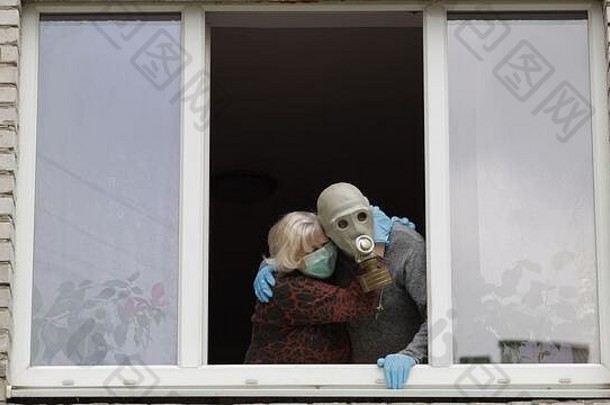 祖父气体面具祖母保护面具保持窗口孤立的首页检疫病毒爆发老男人。女人科维德流感大流行冠状病毒社会距离