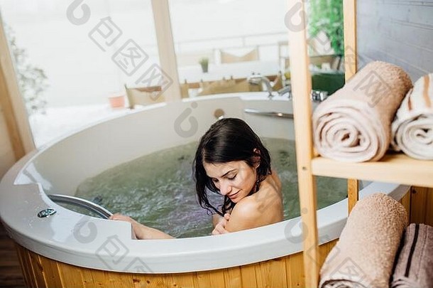 女人放松首页热浴缸浴仪式水疗中心一天时刻现代浴室在室内极可意水流按摩浴缸浴缸身体护理好个人卫生例程斯金卡