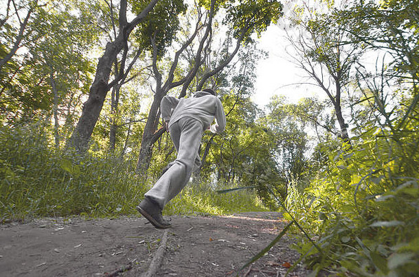 年轻的的家伙灰色的体育西装运行路径树森林体育慢跑在户外运动效果