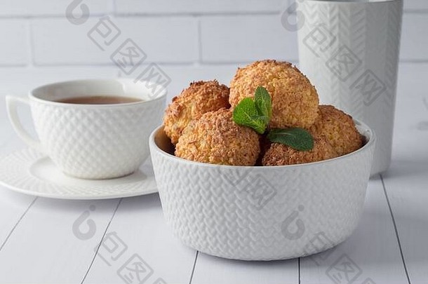 碗美味的椰子饼干茶白色木表格美食谷蛋白免费的甜点美味的自制的饼干新鲜的素食主义者治疗