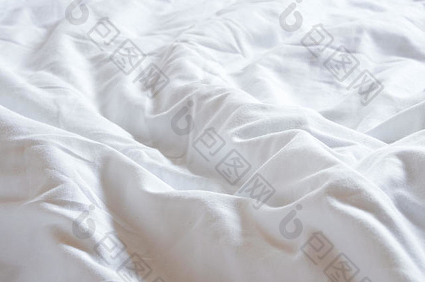 白色毯子皱巴巴的床上
