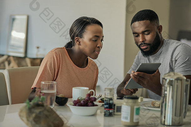 微笑年轻的非洲美国夫妇平板电脑早餐