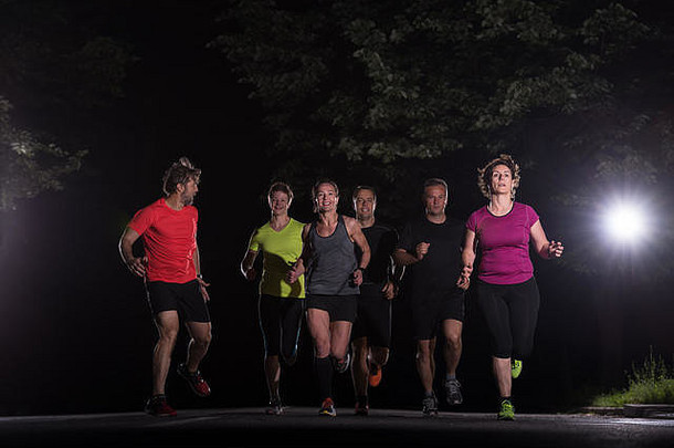集团健康的人慢跑城市公园跑步者团队晚上培训
