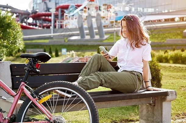 城市骑自行车十几岁的女孩电话自行车城市活跃的生活方式