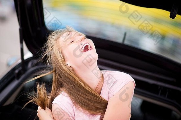 女孩坐在车夏天一天笑着说大声眯着眼看眼睛温暖的积极的周末