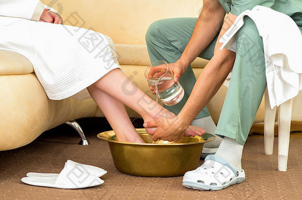 按摩治疗师洗女人的脚按摩过程水疗中心美沙龙