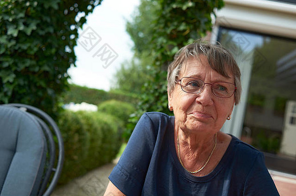 健康的上了年纪的女人坐着回来花园快乐兴奋夏天阳光