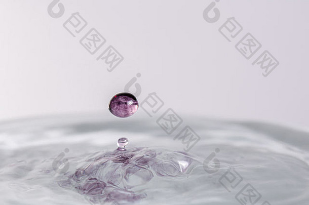 关闭宏摄影紫色的水下降溅水光彩色的白色灰色的背景