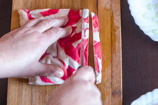 女人的手切割kanikama蟹肉模仿三德刀木切董事会加州寿司卷沙拉汤包装