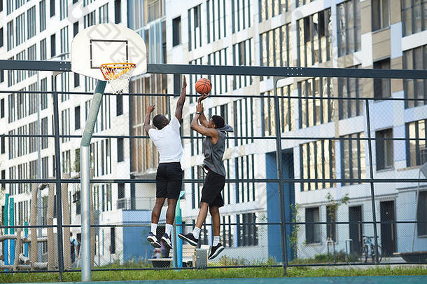 宽角行动拍摄非裔美国人人跳玩篮球户外法院复制空间