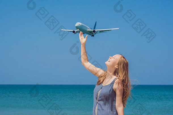 年轻的女人海滩着陆飞机旅行概念