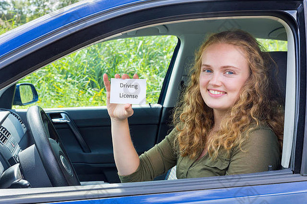 年轻的欧洲女人显示卡开车许可证车