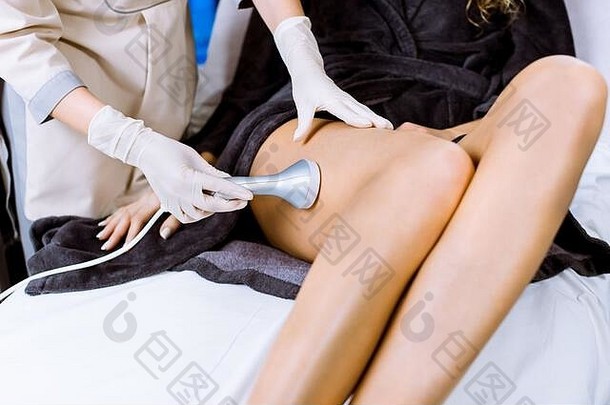 裁剪拍摄年轻的女人rf-lifting治疗腿专业女人美容师美容师执行rf-lifting治疗