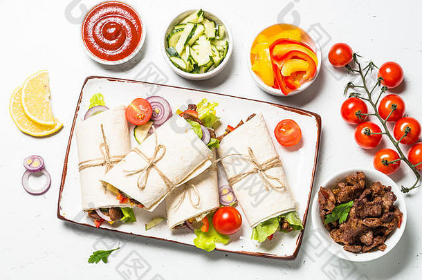 墨西哥卷饼玉米粉圆饼包装成分牛肉蔬菜白色表格传统的拉丁美国食物前视图