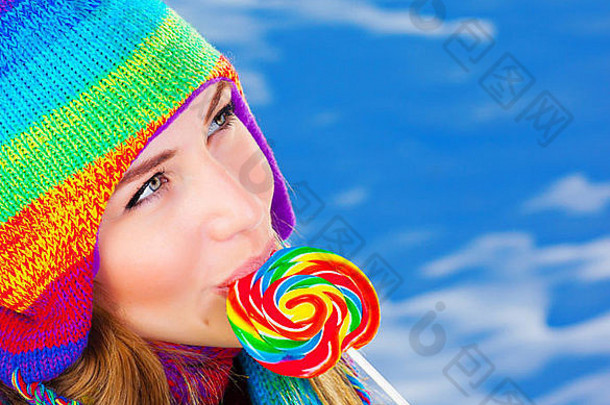 照片漂亮的女孩吃糖糖果户外冬季特写镜头肖像美丽的女穿温暖的色彩斑斓的他