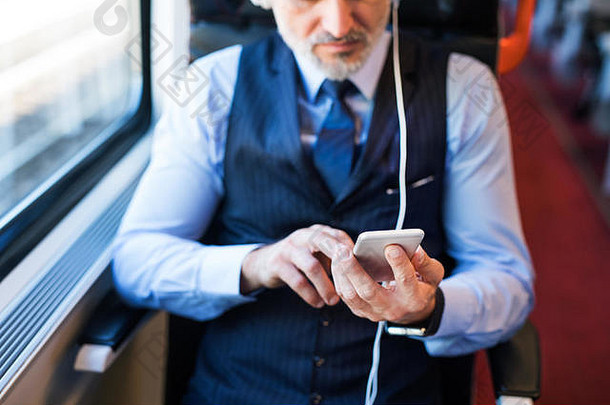 成熟的商人智能手机旅行火车