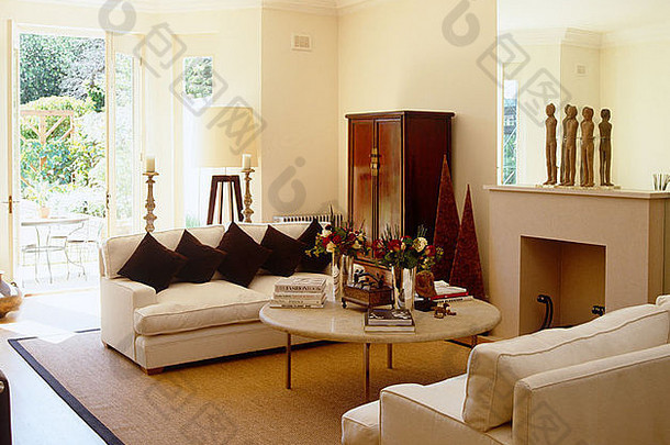 奶油沙发面对咖啡表格前面壁炉当代坐着房间大剑麻地毯