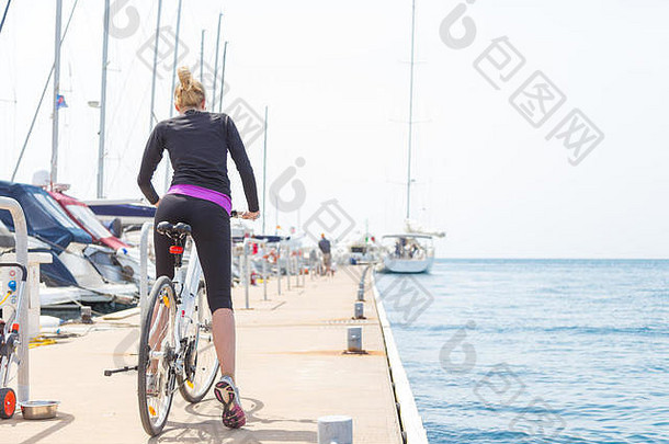 年轻的活跃的女人骑自行车<strong>码头</strong>玛丽娜