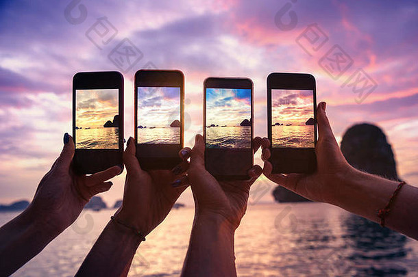 特写镜头照片手移动手机采取照片美丽的日落海湾