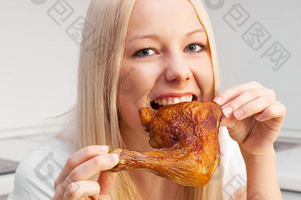 美丽的年轻的金发碧眼的女人吃鸡厨房首页