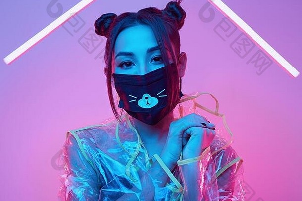 肖像美丽的病毒面具亚洲女人穿脸保护雨衣色彩鲜艳的明亮的霓虹灯灯摆姿势工作室