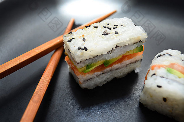 寿司大马哈鱼鳄梨时尚三明治筷子黑色的板