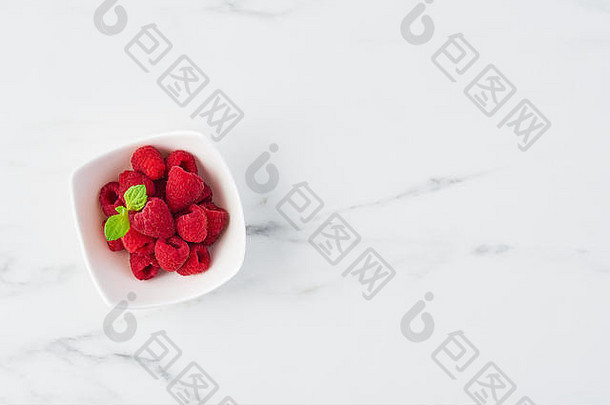前视图新鲜的甜蜜的树莓薄荷叶子白色碗白色大理石表格复制空间