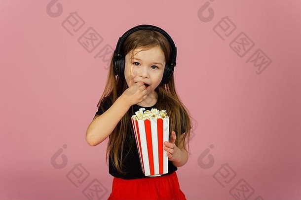 女孩粉红色的柔和的背景<strong>大</strong>耳机吃流行玉米条纹包装概念<strong>电影广告电影</strong>剧院