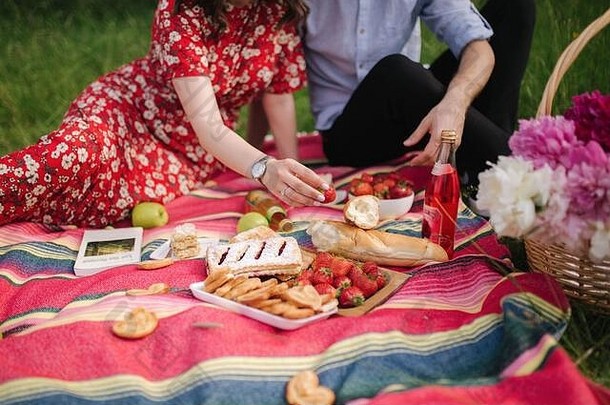 关闭手草莓迷你野餐在户外男人。女人吃