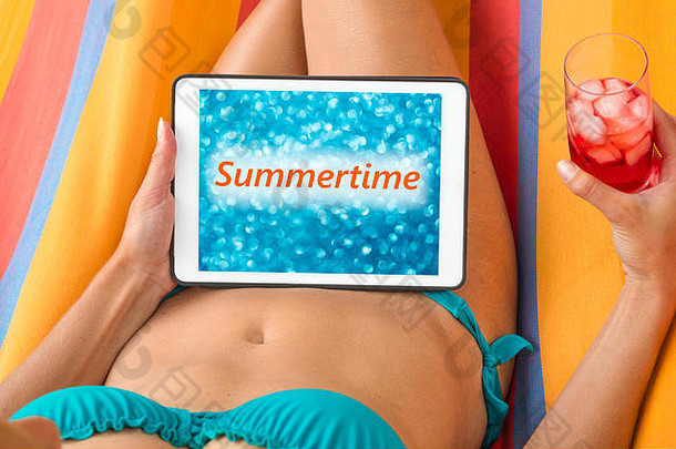 年轻的女人比基尼吊床平板电脑设备模糊蓝色的背景词夏季写