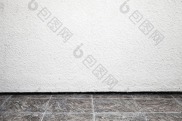 白色室内背景粗糙的粉刷墙瓷砖地板上