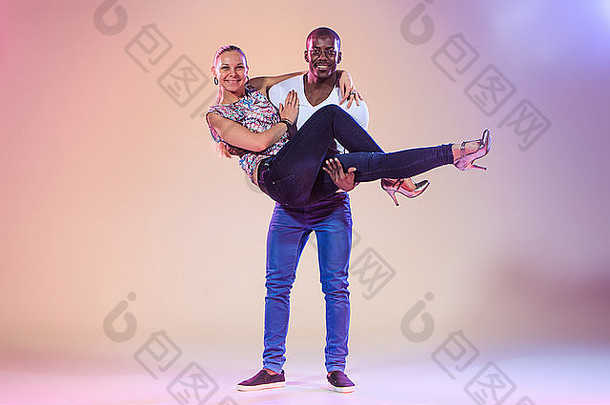 年轻的夫妇<strong>舞蹈社</strong>会加勒比萨尔萨舞工作室拍摄淡紫色背景积极的人类情绪黑色的非洲cauc