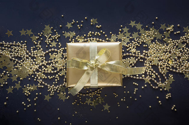 奢侈品金礼物盒子黄金丝带<strong>发光</strong>黑色的背景圣诞节生日聚会，派对现在平躺前视图节日背景圣诞节钱