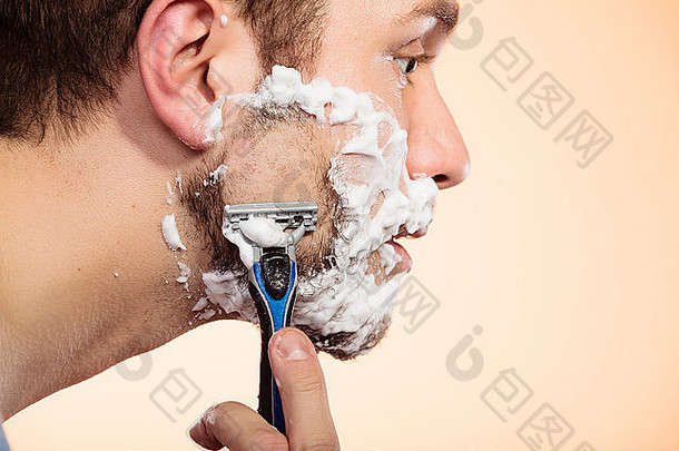 健康美皮肤护理概念特写镜头年轻的有胡子的男人。泡沫脸剃须明亮的橙色背景