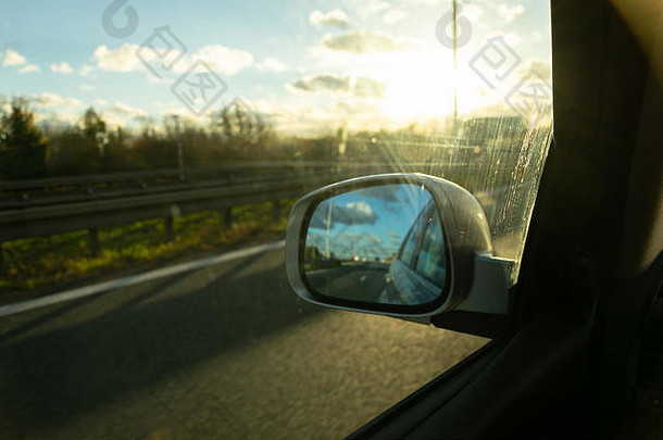 视图高速公路后视镜子背景日落