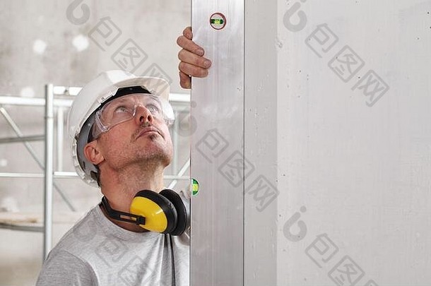 男人。工人精神水平检查墙硬他眼镜耳朵保护耳机白色墙复制空间