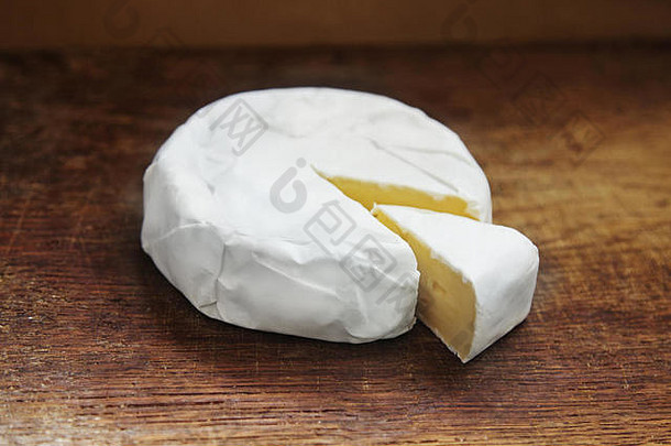 奶油布里干酪减少一块乡村木背景