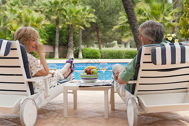上了年纪的夫妇享受玻璃白色酒太阳便鞋池