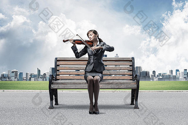 年轻的女人小提琴坐着木板凳上